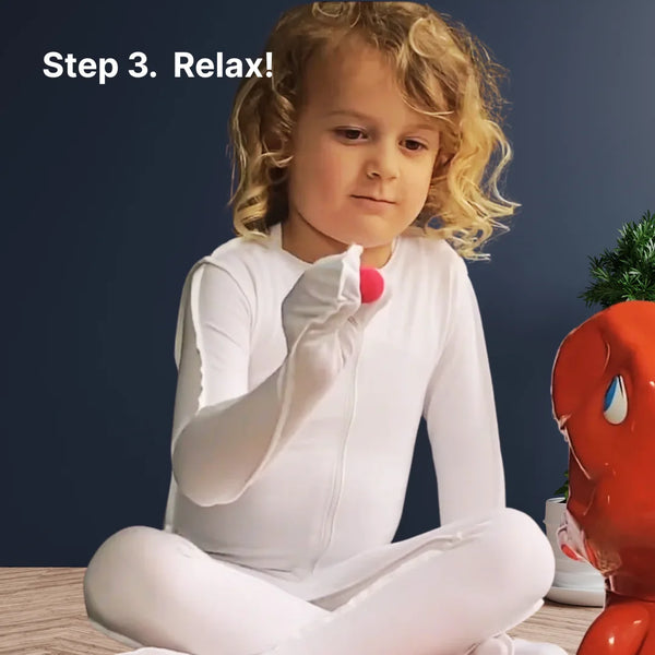 Child in a white skinakin suit playing a ball game happily.